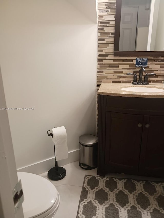 bathroom featuring decorative backsplash, tile patterned flooring, vanity, and toilet