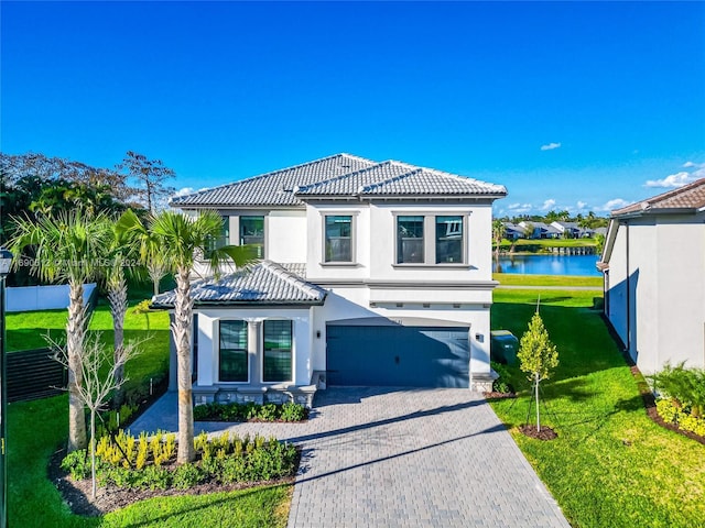 mediterranean / spanish-style house featuring a garage, a water view, and a front yard