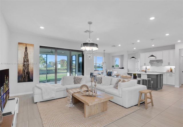 living room featuring an inviting chandelier and sink