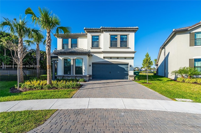 mediterranean / spanish home with a garage and a front lawn