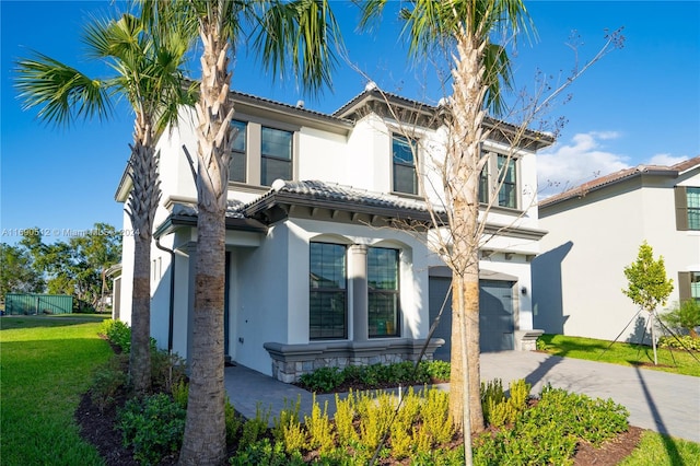 mediterranean / spanish house with a front yard and a garage