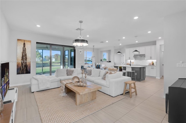 living room with light tile patterned flooring, sink, and an inviting chandelier