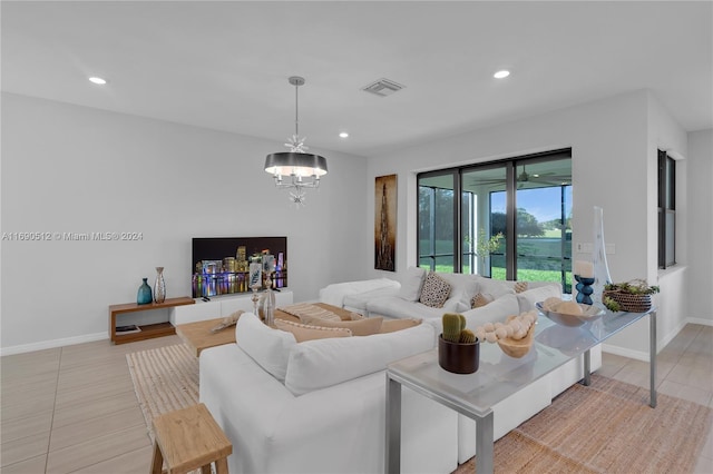 tiled living room with an inviting chandelier