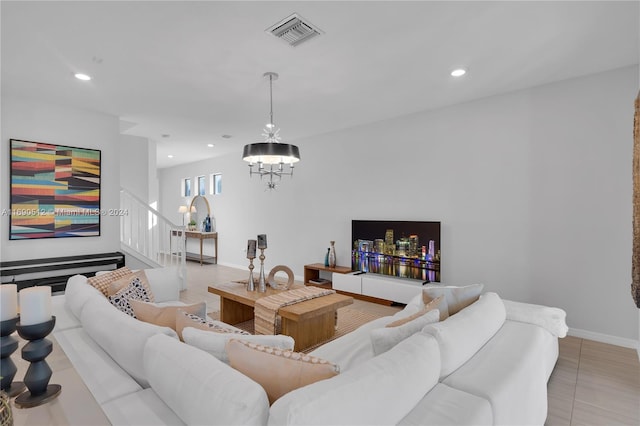 tiled living room featuring a notable chandelier