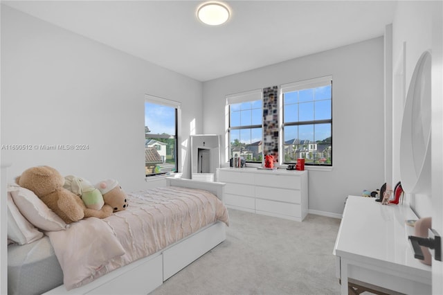 bedroom featuring light carpet and multiple windows