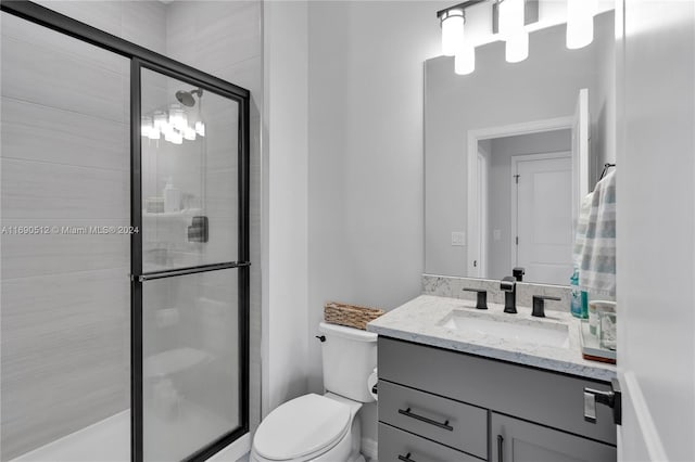 bathroom with walk in shower, vanity, and toilet