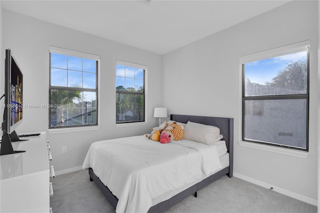 carpeted bedroom featuring multiple windows