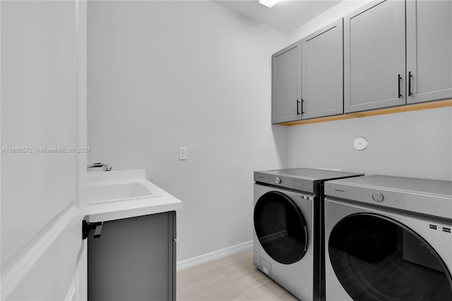 laundry area with washer and dryer, sink, light tile patterned floors, and cabinets