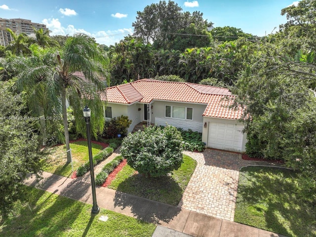 mediterranean / spanish-style house with a garage and a front yard