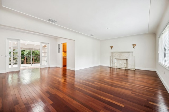 unfurnished living room featuring a fireplace, french doors, and dark wood-type flooring