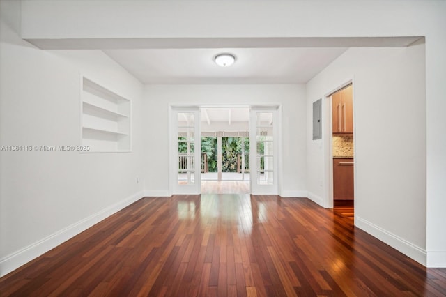 unfurnished living room featuring built in features, dark wood-type flooring, and french doors