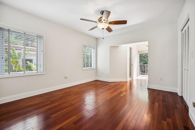 unfurnished bedroom featuring multiple windows, ceiling fan, and dark wood-type flooring