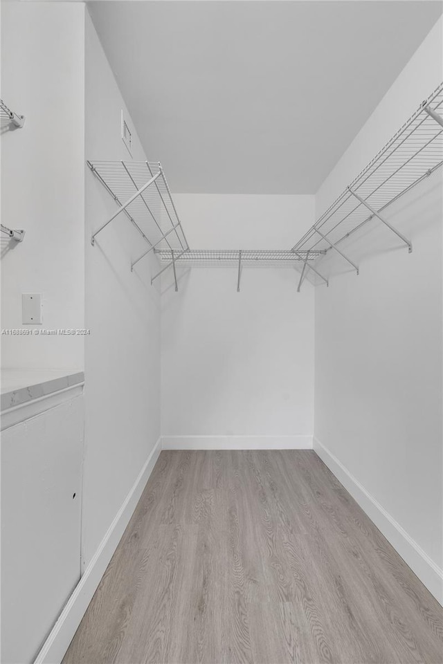 spacious closet with light hardwood / wood-style flooring