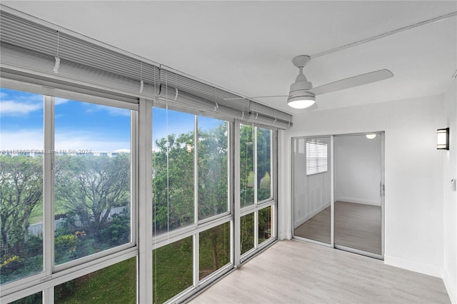 unfurnished sunroom with ceiling fan