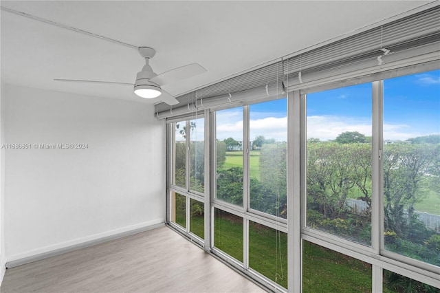 unfurnished sunroom featuring ceiling fan