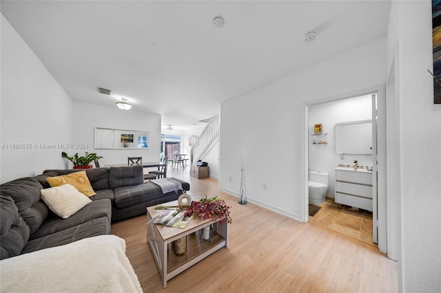 living room with light hardwood / wood-style floors and sink