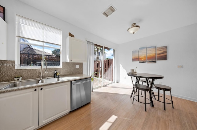 kitchen featuring white cabinets, plenty of natural light, dishwasher, and tasteful backsplash