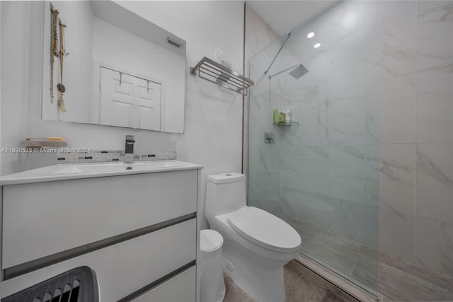 bathroom featuring vanity, toilet, and a tile shower