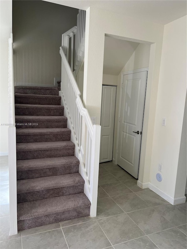 staircase featuring tile patterned flooring