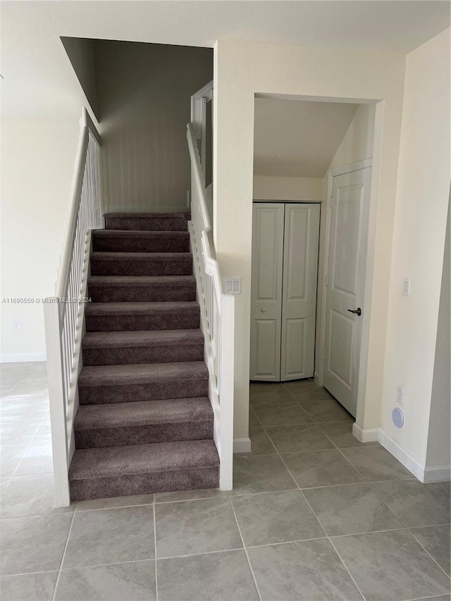 stairway featuring tile patterned flooring