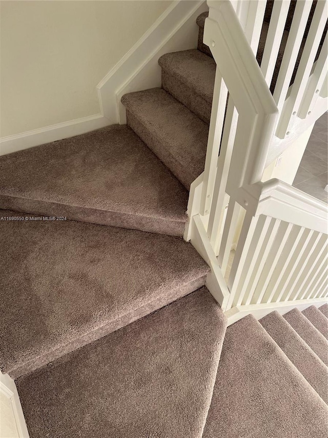 staircase featuring carpet flooring