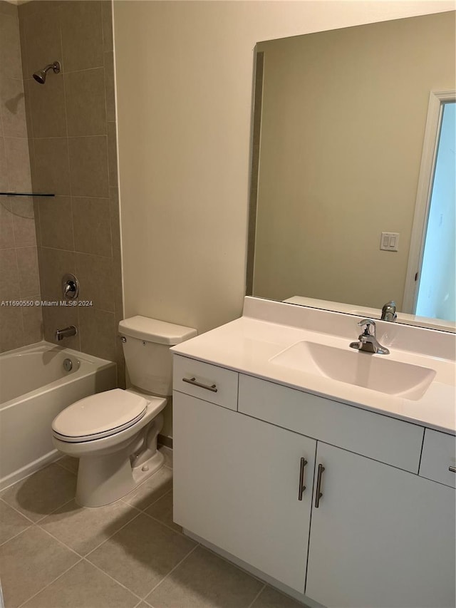 full bathroom with toilet, vanity, tiled shower / bath combo, and tile patterned floors