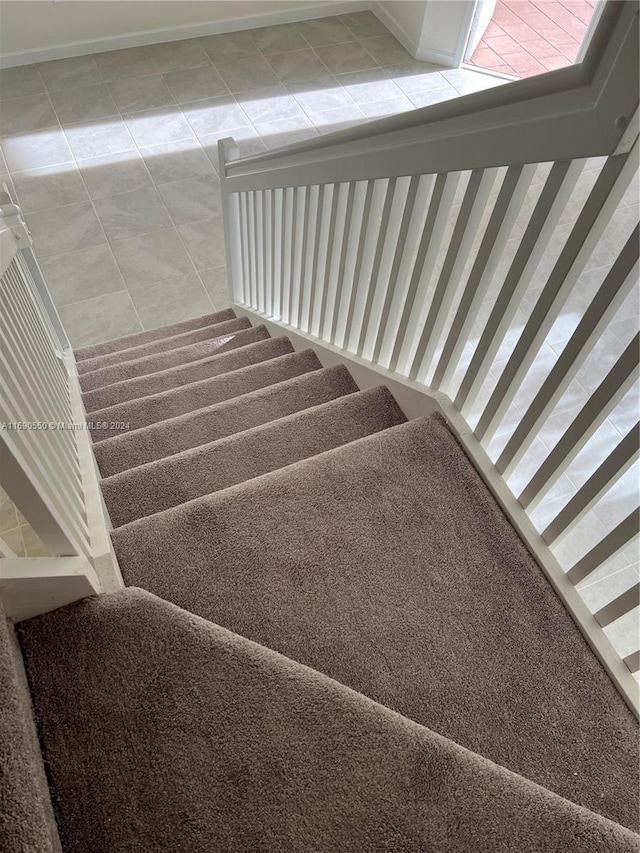 staircase featuring tile patterned floors