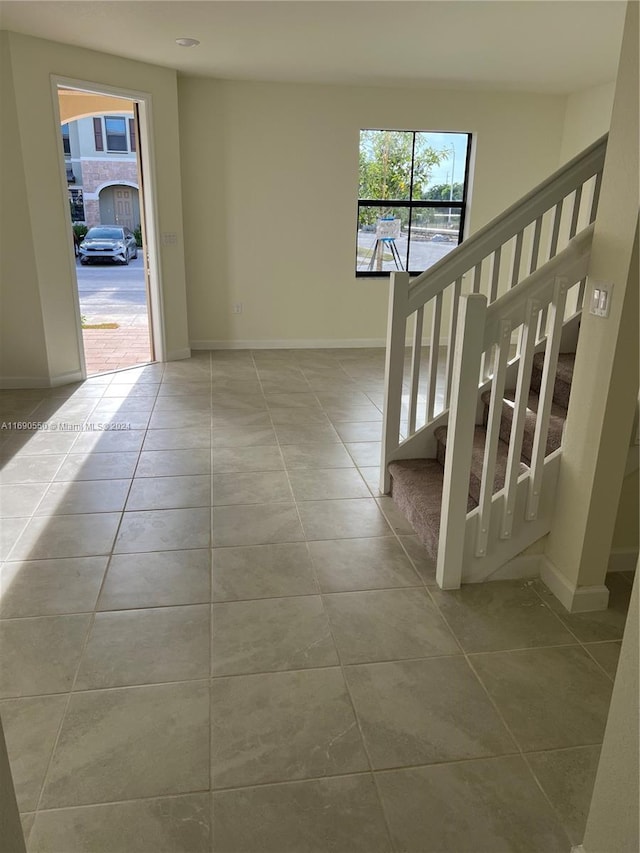 hallway with a wealth of natural light and light tile patterned floors