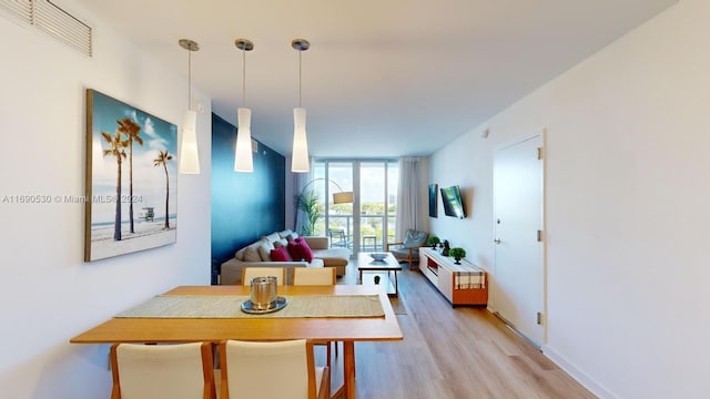 dining room featuring a wall of windows and light hardwood / wood-style floors