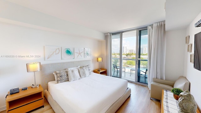 bedroom with access to exterior, light hardwood / wood-style floors, and floor to ceiling windows