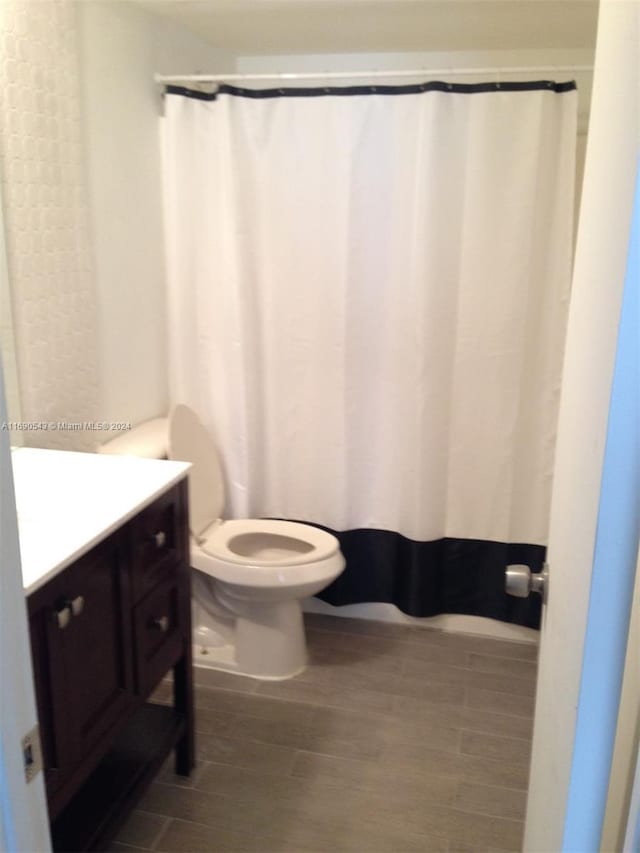 bathroom featuring toilet, vanity, and hardwood / wood-style flooring