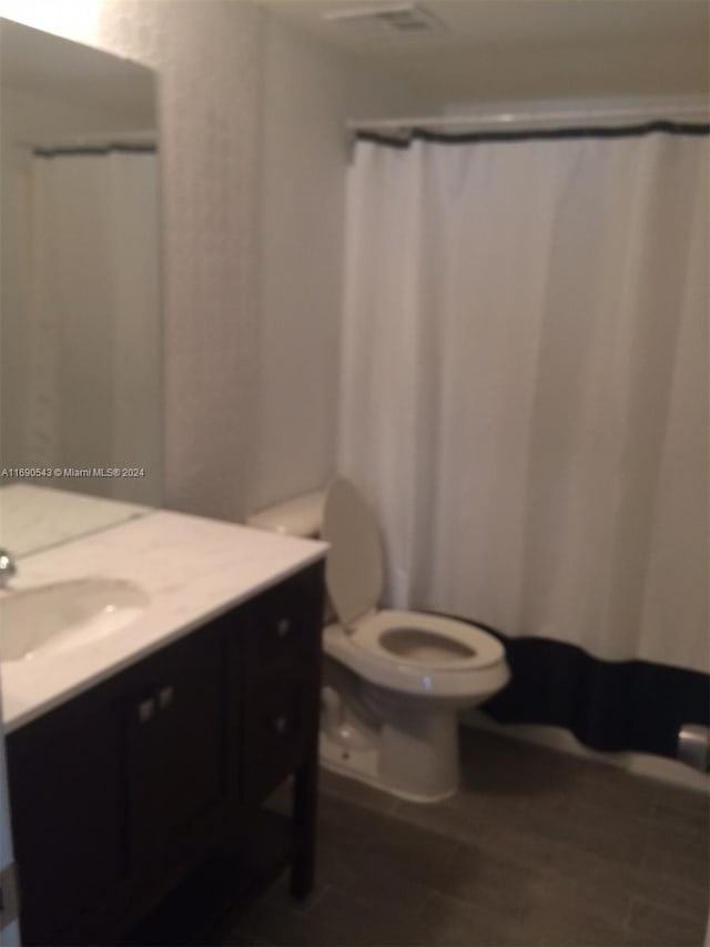 bathroom featuring toilet, vanity, and hardwood / wood-style flooring