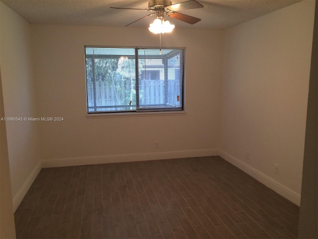 empty room with dark wood-type flooring, ceiling fan, and a textured ceiling