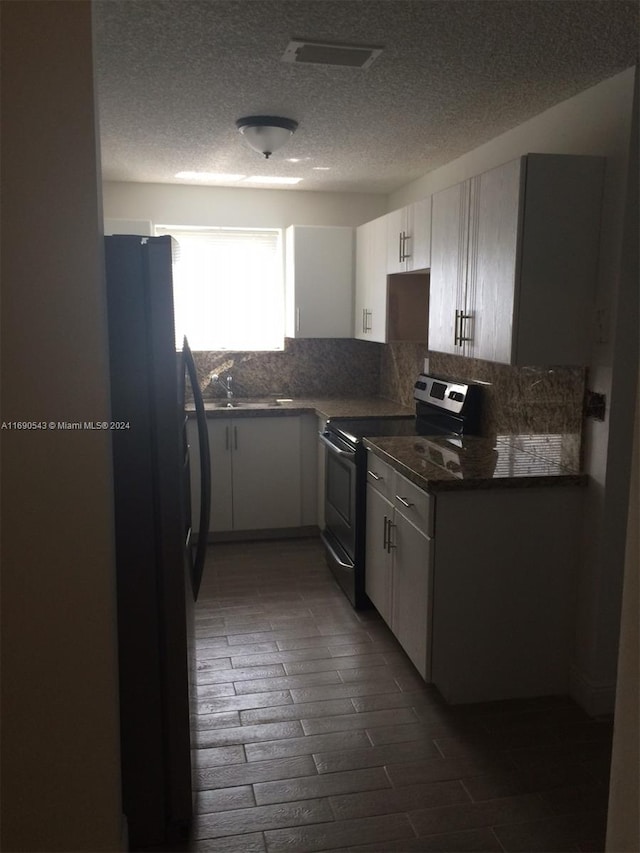 kitchen with white cabinetry, stainless steel range with electric stovetop, backsplash, fridge, and dark hardwood / wood-style flooring