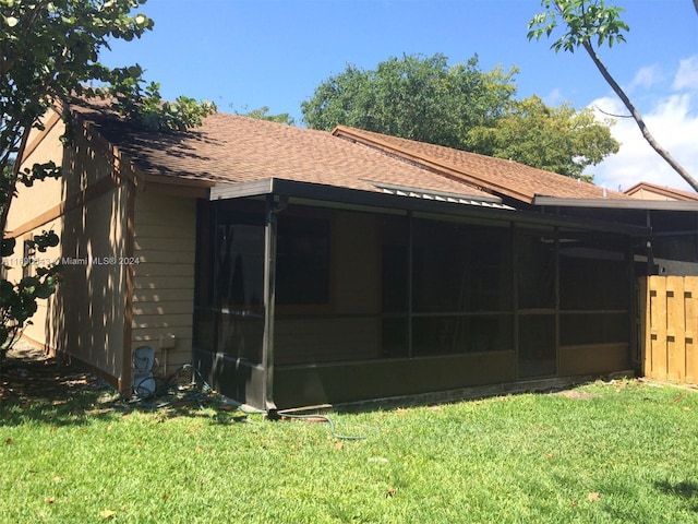 view of side of home featuring a lawn and a sunroom