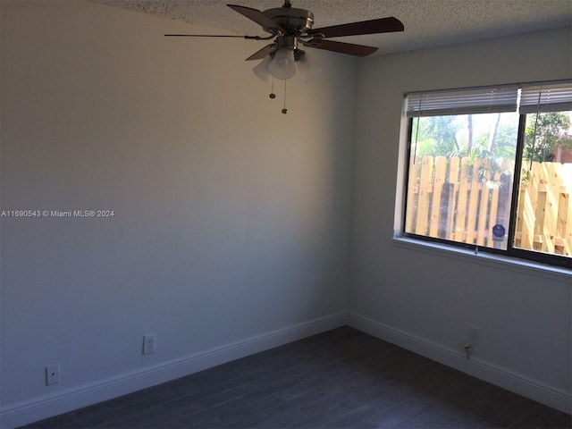 empty room featuring ceiling fan, dark hardwood / wood-style floors, and a textured ceiling