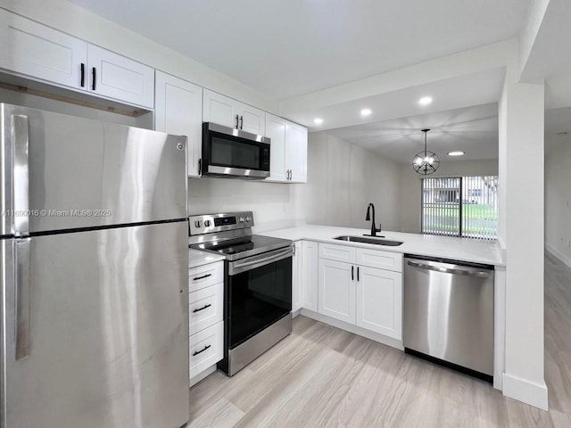 kitchen with sink, light hardwood / wood-style floors, white cabinets, and appliances with stainless steel finishes