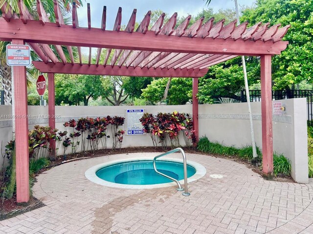 view of pool with a hot tub and a pergola