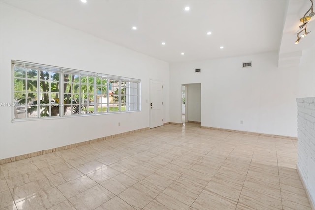 unfurnished room with plenty of natural light and baseboards