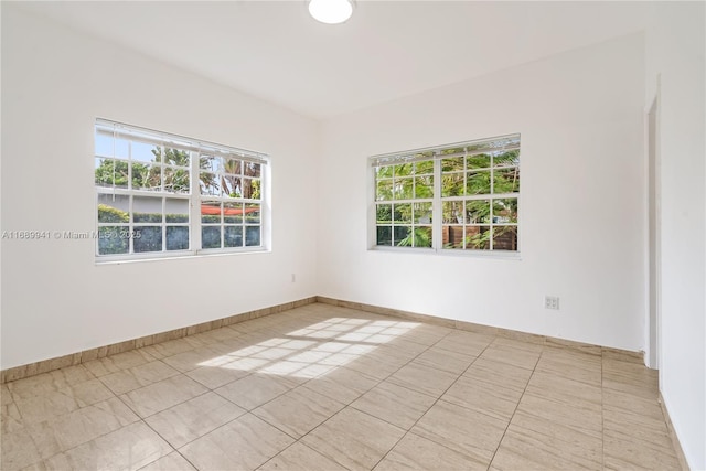 unfurnished room with plenty of natural light and baseboards
