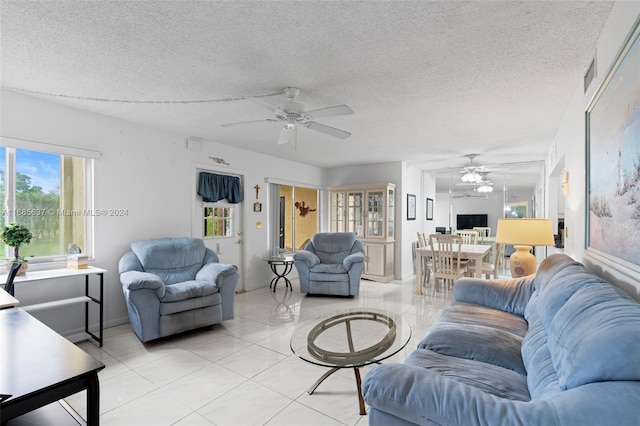 living room with a textured ceiling and light tile patterned floors