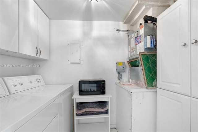 laundry room featuring cabinets, washer and dryer, and electric panel