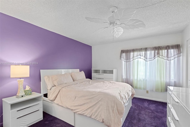 bedroom featuring a textured ceiling, dark carpet, and ceiling fan