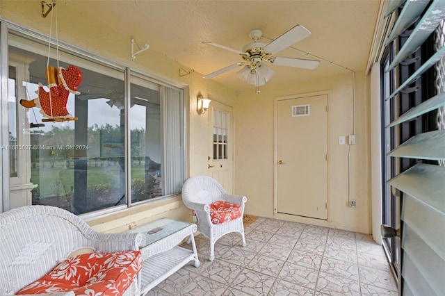 sunroom / solarium featuring a wealth of natural light and ceiling fan