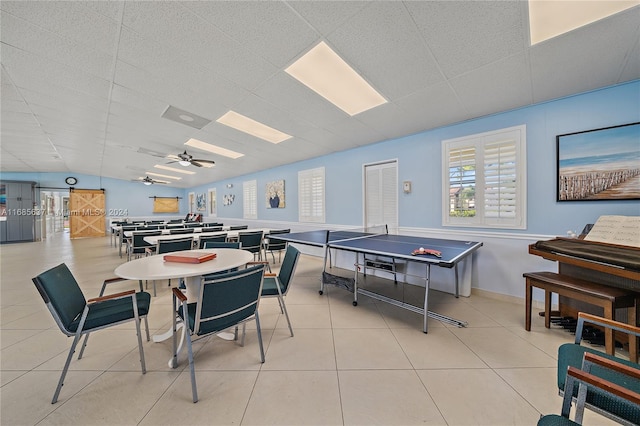 recreation room featuring ceiling fan, light tile patterned floors, and lofted ceiling