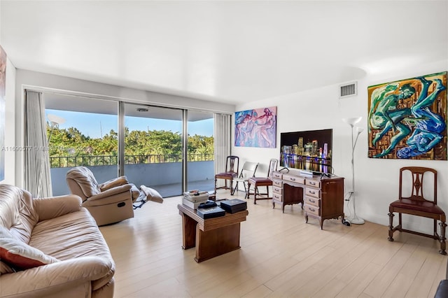 living room with light wood-style floors and visible vents