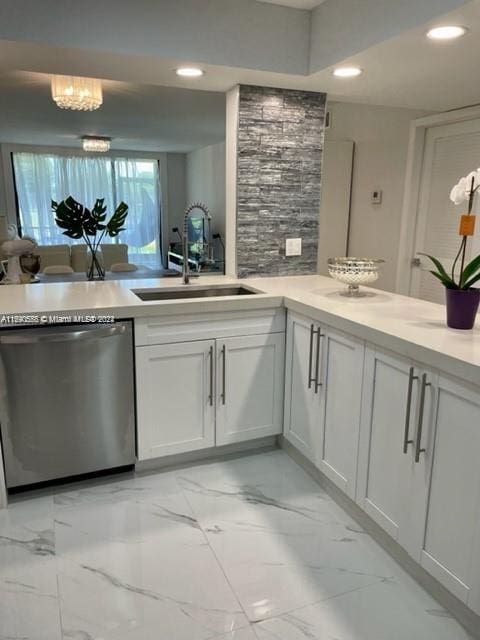 kitchen featuring white cabinetry, sink, dishwasher, and a notable chandelier