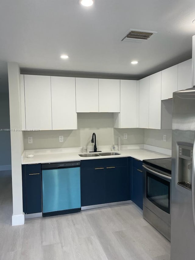 3731 SW 58th Ter, Davie, FL 33314 - kitchen with white cabinetry, stainless steel appliances, light hardwood / wood-style floors, and sink