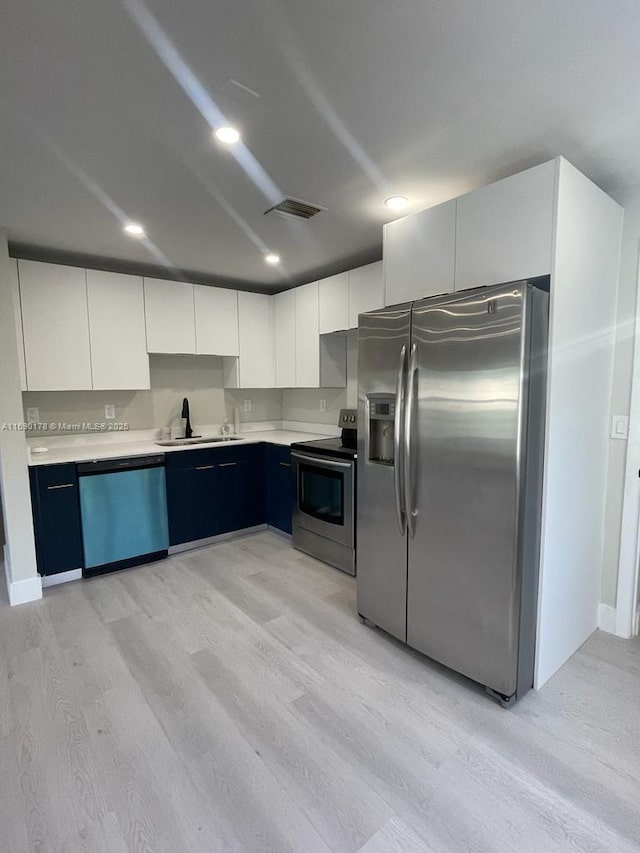 3731 SW 58th Ter, Davie, FL 33314 - kitchen with white cabinetry, appliances with stainless steel finishes, sink, and light wood-type flooring