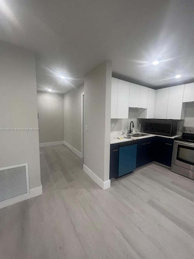 3731 SW 58th Ter, Davie, FL 33314 - kitchen with sink, light hardwood / wood-style flooring, stainless steel appliances, and white cabinets